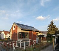 Zu sehen ist ein Haus mit Solarkollektoren und PV-Modulen