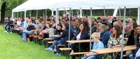 Gut gefüllt waren die Zuschauerbänke im Freibad Goddelau. Unter einem großen weißen Zeltdach sitzen viele Menschen und verfolgen die Jugendsportlerehrung.