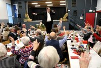 Patrick Fiederer steht auf einem Stuhl und singt.