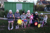 Kinder der Kita Büchnerstraße sitzen mit ihren Laternen auf einer Wippe.