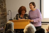 Suzann Bohn und die Riedstädter Frauen- und Gleichstellungsbeauftragte Jennifer Muth (von links) stehen am Stehpult und lachen.