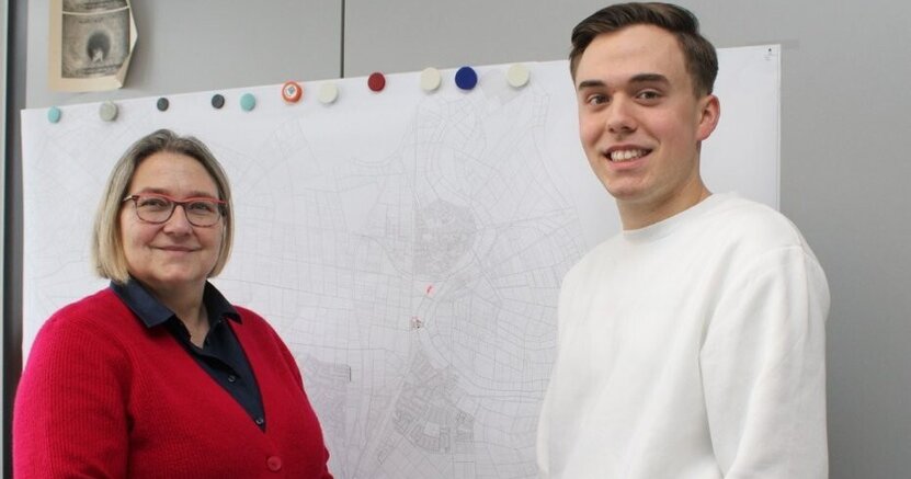 Stadtwerkeleiterin Saskia Kirsch und Dualer Student Florian Schmidt stehen vor einer Karte.