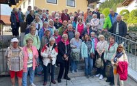 Fröhliche Teilnehmerinnen und Teilnehmer der Riedstädter Seniorenfahrt Seniorinnen und Senioren stehen auf und vor der Außentreppe eines Gebäudes.