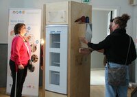 Eine Besucherin testet einen Wärmetauscher in der Ausstellung