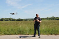Niklas Schnepel mit Steuergerät, vor ihm fliegt die kleine Drohne