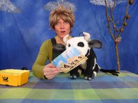 Zu sehen ist die Bäuerin, die der Handpuppe Lieselotte eine Postkarte zeigt.