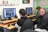 Jugendpfleger Kai Faßnacht berät Simon (li) und Robin bei der Fotosichtung.