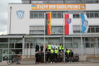 Die Mitglieder des Spendenlaufs stehen vor dem Riedstädter Rathaus. An der Fassade hängt das Banner "Stopp den Krieg, Putin!"