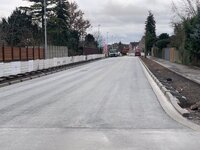 Zu sehen ist ein neu asphaltierter Straßenabschnitt der Ortsdurchfahrt. 