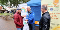 Informationen gab es auch am Stand der Bürger Solar Berater Ried und der Energie Gemeinschaft Ried. Drei Männer unterhalten sich vor Plakaten, auf denen sich die Solar Berater Ried und die Energie Gemeinschaft Ried vorstellen.