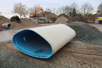 Im Vordergrund ein neues Kanalrohr, im Hintergrund die alten Rohre.