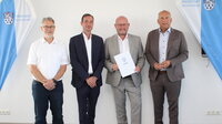 Die Bürgermeister Thomas Raschel (Stockstadt), Marcus Rahner (Biebesheim) und Marcus Kretschmann (Riedstadt) mit dem Hessischen Innenminister Roman Poseck (v.re.) bei der Bescheidübergabe im Riedstädter Rathaus. Im Sitzungssaal des Riedstädter Rathauses stehen der Bürgermeister von Stockstadt Thomas Raschel, der Bürgermeister von Biebesheim Marcus Rahner, der Bürgermeister von Riedstadt Marcus Kretschmann und der Hessische Innenminister Roman Poseck nebeneinander (von links nach rechts). Bürgermeister Kretschmann hält eine Mappe mit der Aufschrift "Hessen" in der Hand. Links und rechts von den Herren sind Ständer mit dem blau-weißen Wappen von Riedstadt sowie dem Schriftzug '"Riedstadt. Büchnerstadt" in Blau zu sehen.