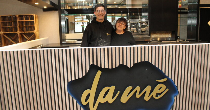 Enzo und Nora Santacroce stehen hinter der Theke im Bürgerhaus mit der Aufschrift "da mé"