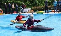 Auch Schnupperpaddeln gehörte zum Angebot. Eine Frau und ein Mann sitzen jeweils in einem Kajak und paddeln im Schwimmerbecken.