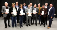 Auf der Bühne der Heinrich-Bonn-Halle stehen die Ausgezeichneten mit Ehrenplaketten und Urkunden. Von links nach rechts:Dieter Frey, Katja Kamenik, Matthias Lachmann, Melanie Dörr, Guido Funk, Ahmad Muzaffar Mahmood, Michael Fraikin, Matthias Thurn, Ottmar Eberling, Frank Fischer, Heiko Büßer und Bürgermeister Marcus Kretschmann 