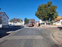 Zu sehen ist die Hauptstraße in Leeheim, von der links die Erfelder Straße abgeht und rechts die Riedhäuserhofstraße. Rechts im Bild sind Absperrungen zu sehen.