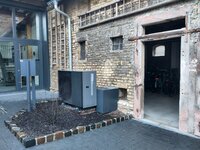 Vor der Außenwand eines Hauses steht eine Wärmepumpe.