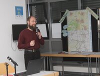 Sanierungsmanager Benjamin Krick spricht in ein Mikrofon.