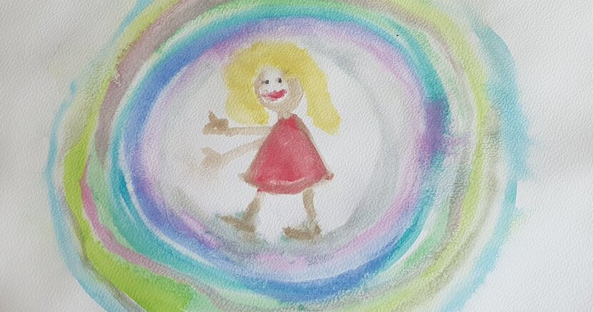 Gezeigt wird ein Gemälde aus der Bannerausstellung. Es zeigt einen Menschen in der Mitte von bunten Kreisen.