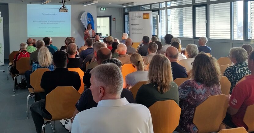 Großes Interesse gab es am Thema Öltanks. Die vielen Stuhlreihen im Sitzungssaal des Riedstädter Rathauses sind voll besetzt. Die Menschen sind von hinten zu sehen. Am Ende des Saales sind eine Leinwand und ein Vortragender zu sehen.
