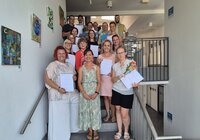 Die erfolgreichen Kita-Führungskräfte mit ihren Zertifikaten. Es gratulierten auch die Pädagogische Fachberaterin Nadja Pfitzner (vorne Mitte) und Fachbereichsleiter Rick Hölzer (hinten rechts) Die erfolgreichen Kita-Führungskräfte stehen mit ihren Zertifikaten auf der Treppe im Riedstädter Rathaus.
