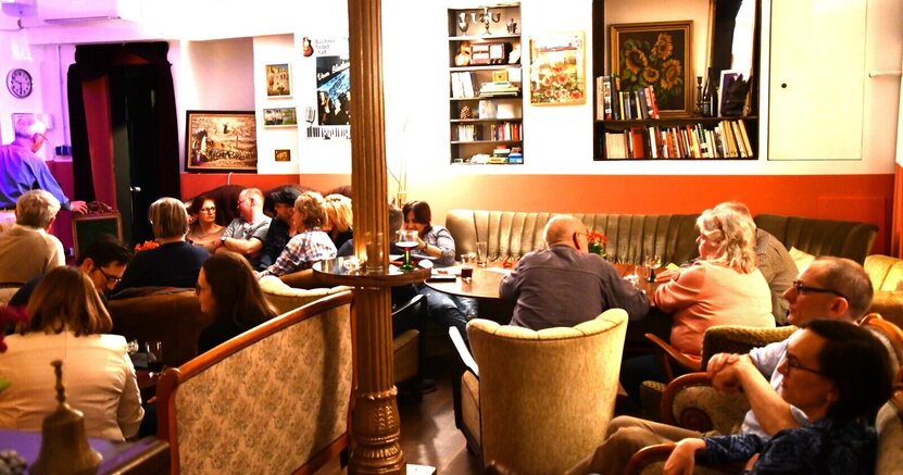 Zu sehen sind Menschen, die im Theatercafé der BüchnerBühne sitzen.