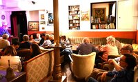 Das Theatercafé der BüchnerBühne. Zu sehen sind Menschen, die im Theatercafé der BüchnerBühne sitzen.