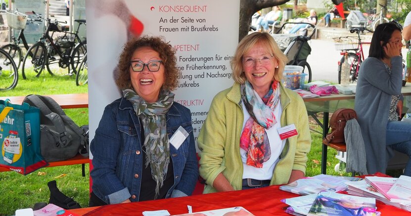 Karina Bonert und Renate Schonemakers (v.li.) vom Verein mamazone sitzen hinter einem Infostand.