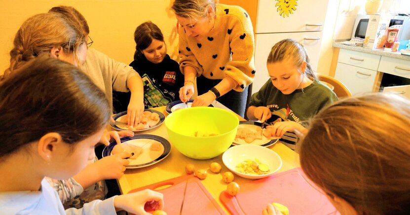 Zu sehen ist Jugendpflegerin Julia Spitzer mit Kindern beim Kochen. Das war ein Programmpunkt im letzten WinterFun. Dieses Mal gibt es einen Kunstworkshop mit ihr.