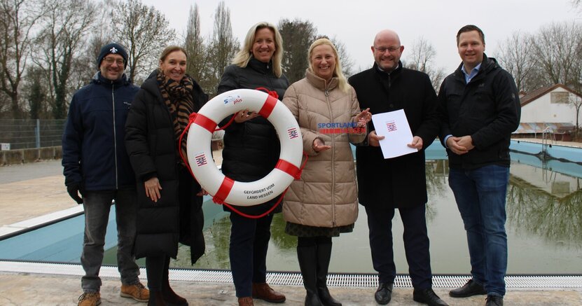 Vor dem Schwimmerbecken im Freibad Goddelau stehenBäderleiter Uwe Tresch, Fachgruppenleiterin Immobilienmanagement Inna Wedel, Landtagsabgeordnete Ines Claus, Staatsministerin Diana Stolz, Bürgermeister Marcus Kretschmann und Alexander Schaper, Fachbereichsleiter Finanzen (v.li.) .