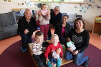 Die Reparierer Günter Kleinwächter und Matthias Wild mit Kitaleiterin Sabine Gunst-Bühler, der stellvertretenden Kitaleiterin Beate Penzel (v.li.), begeisterten Kindern und den neuen Babypuppen.