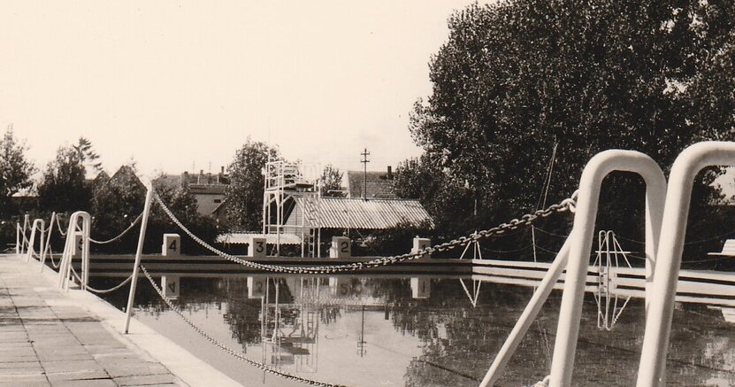 Zu sehen ist ein altes Schwarz-Weiß-Foto mit dem Schwimmerbecken. Das Foto stammt aus der Anfangszeit des Freibads.