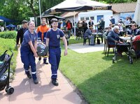 Die Riedstädter Jugendfeuerwehr zeigte, wie ein "Verletzter" richtig abtransportiert wird. Jugendliche in der Uniform der Jugendfeuerwehr transportieren auf einer Bahre einen jungen Mann ab. Der tut so, als sei er verletzt.