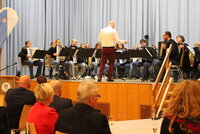 Die Akkordia 73 Crumstadt bestritt das musikalische Rahmenprogramm. Musikerinnen und Musiker der Akkordia 73 Crumstadt sitzen mit ihren Akkordeons auf der Bühne und spielen. Vor ihnen steht der Dirigent Marc Fischer.