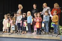 Kinder der evangelischen Kita stehen mit selbst gebastelten Laternen auf der Bühne und singen.