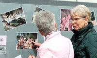 Bürgermeister Marcus Kretschmann hielt die Festrede. Zwei ältere Frauen mit grauen Haaren stehen vor einer Wand mit alten Fotos des Schwimmbads.